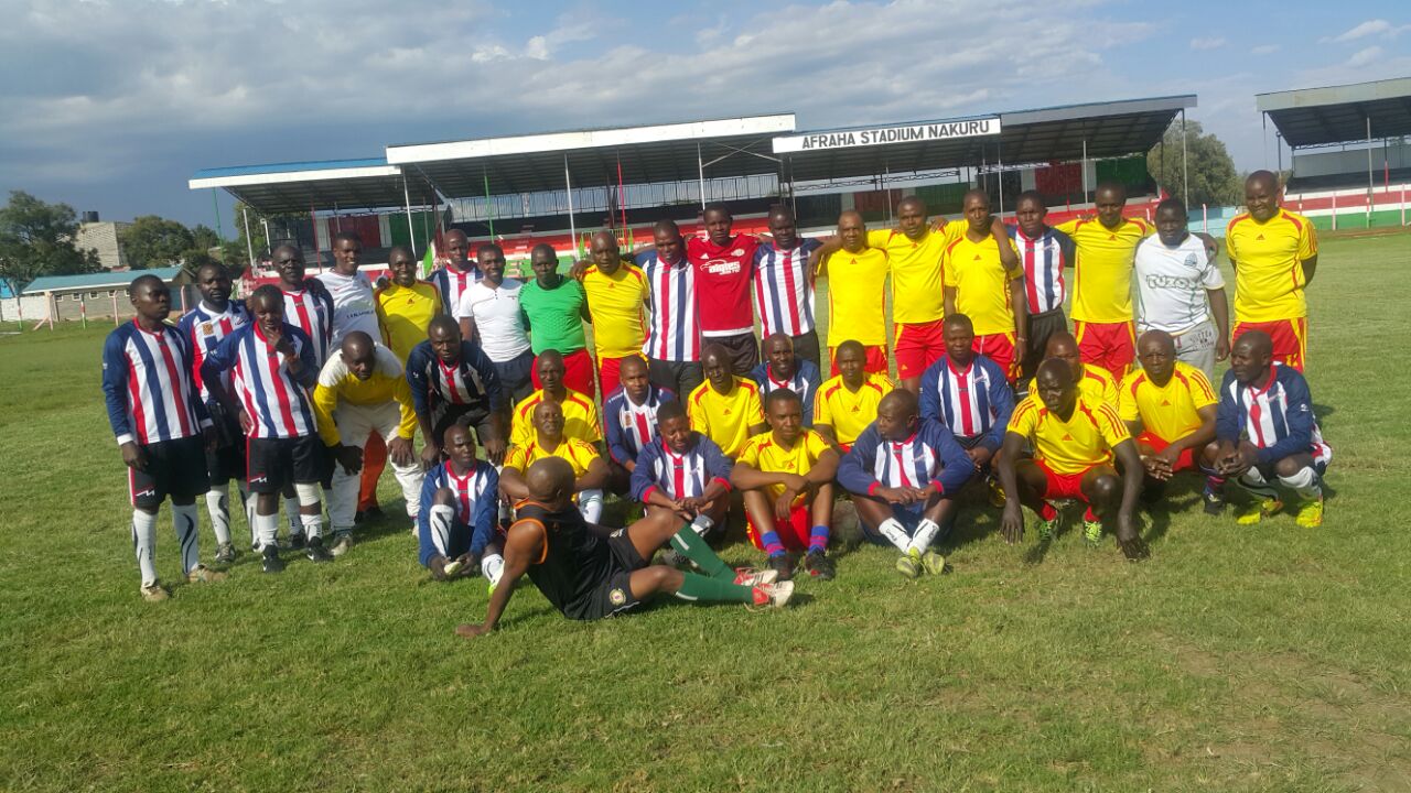 Both teams pose together for a group photo after the final whistle